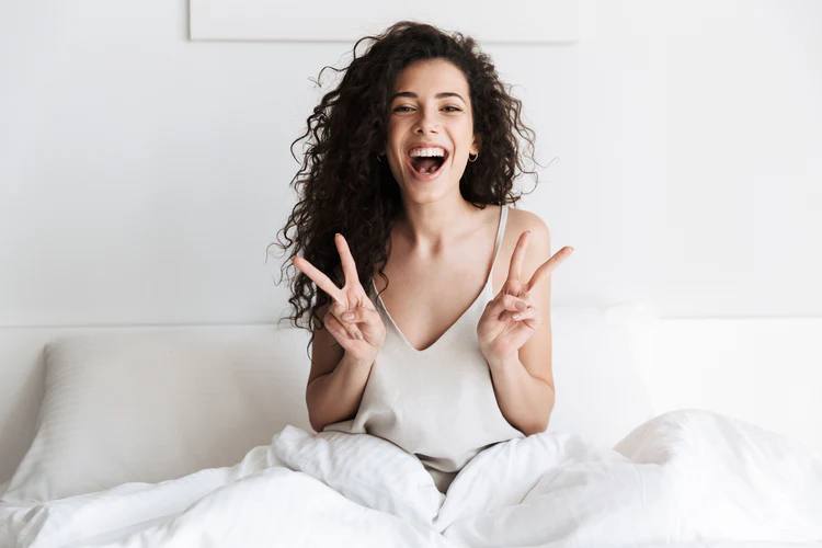 Happy person sitting in bed for BedsRus